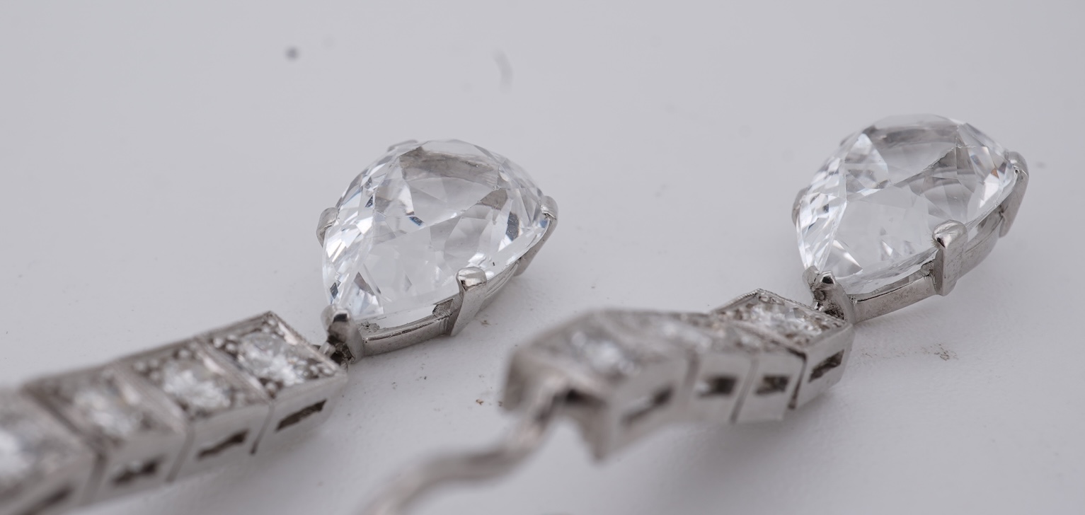 A pair of white metal and four stone diamond set earrings, each with a cubic zirconia pear shaped drop, overall 42mm.